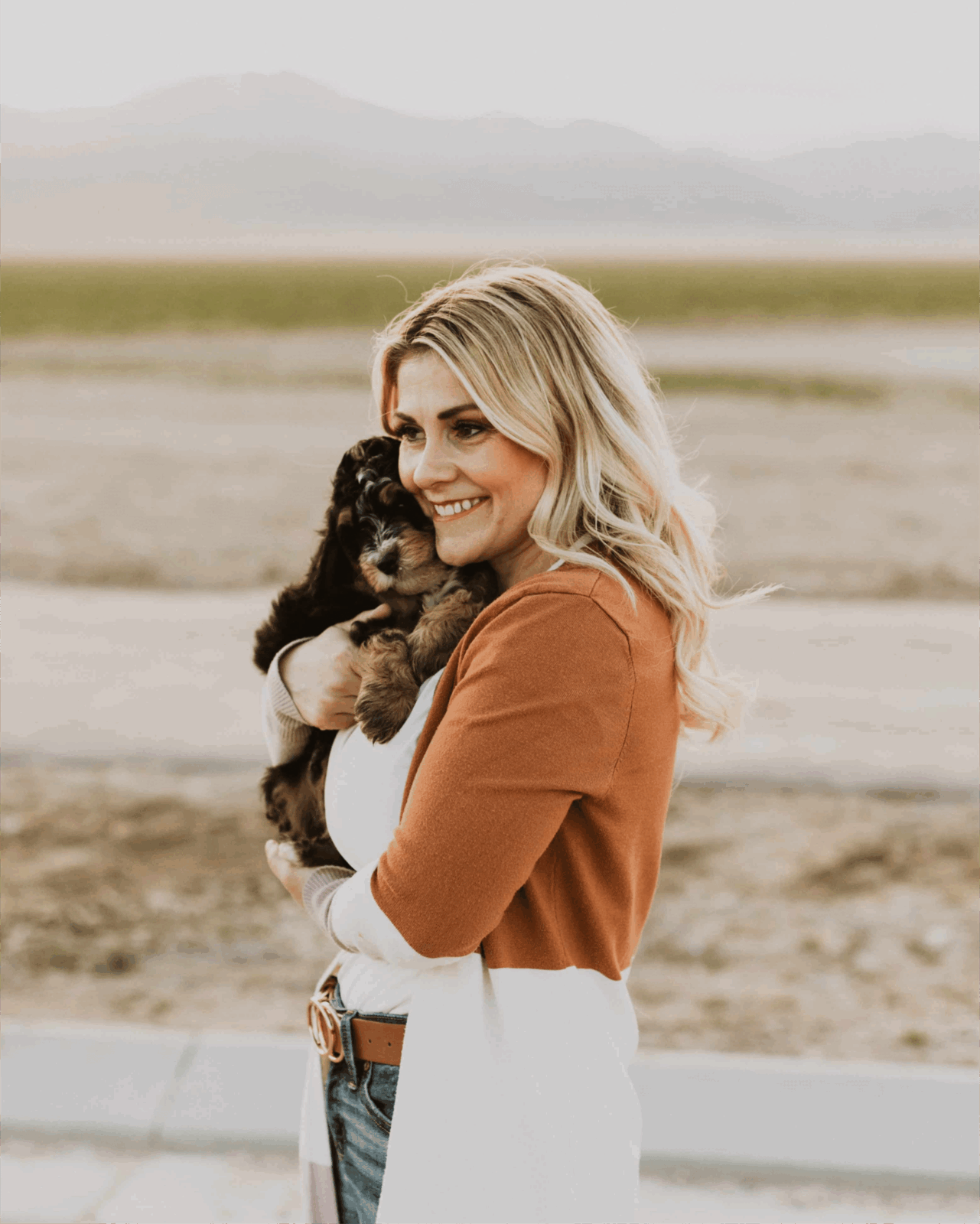 Woman holding small puppies outdoors