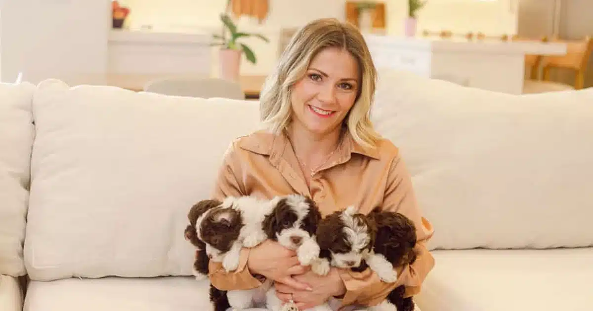 Woman holding several small puppies for Utah pickup day