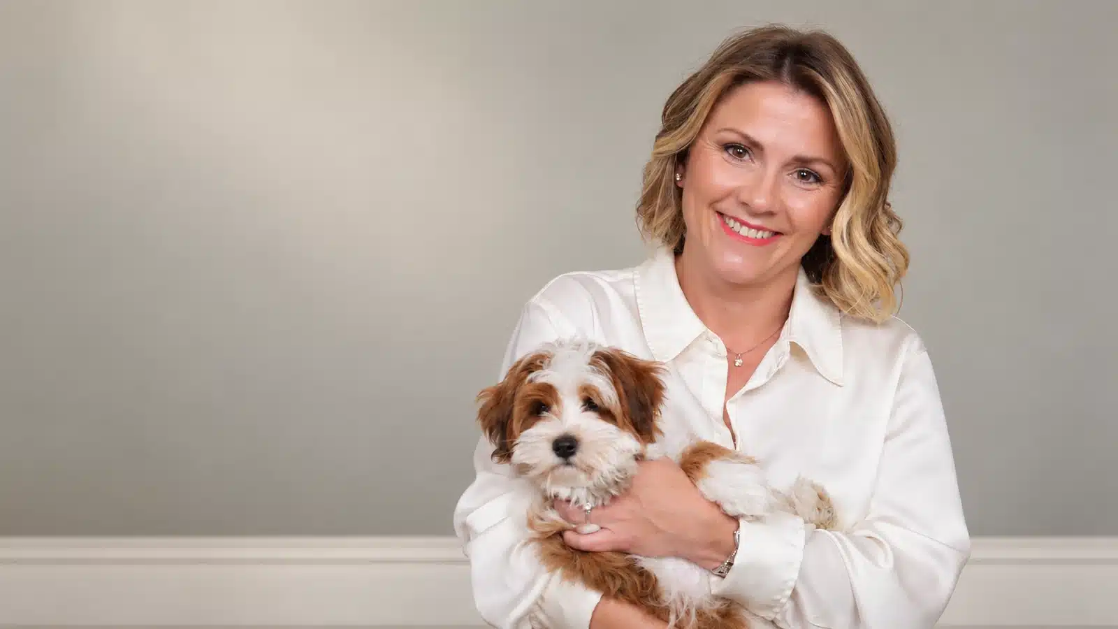 Cassie Milar holding a red and white Havapoo puppy